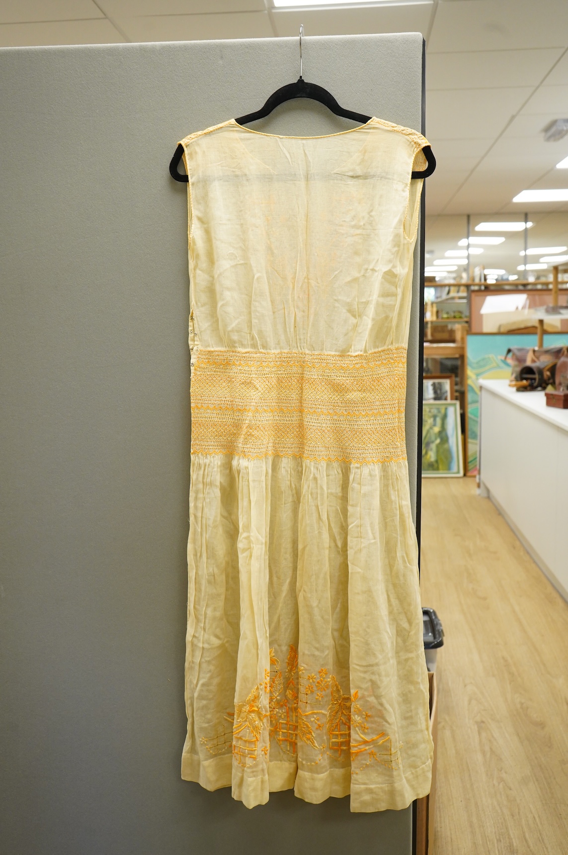 A 1920-30's fine yellow cotton gauze, embroidered and smocked day dress. 117cm long. Condition - good